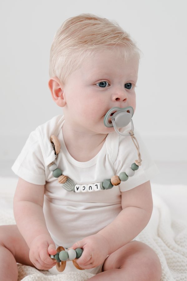 foto met luca en zijn speenkoord en bijtring met naam voor een jongen regenboog groen