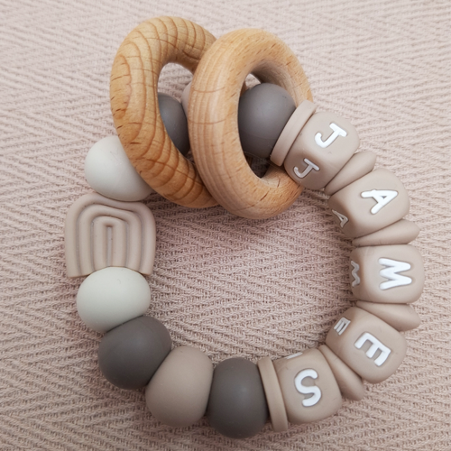 Bijtring met naam jongen regenboog beige