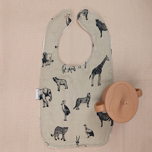 Een handgemaakte babyslab wildlands voor de eerste hapjes met unieke printjes aan de voorkant en absorberende tussenlaag voor droge shirtjes onder de slab