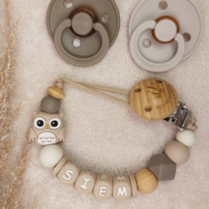 Speenkoord met naam voor een jongen in neutrale beige tinten, afgewerkt met een schattige uil. Gemaakt van veilige, BPA-vrije siliconen kralen. Een praktisch en persoonlijk kraamcadeau dat elke dag van pas komt.