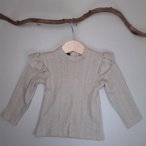 Handgemaakt longsleeve shirt met ruffle op de schouders. Verkrijgbaar in de maat 50- 74. Stof is een rekbare ajour katoen.