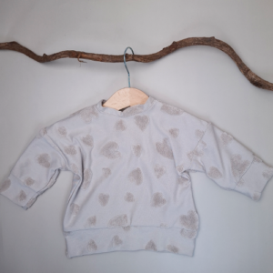 Handgemaakte baby sweater met hartjes in de kleur. met drukknoopjes in de hals taupe. Verkrijgbaar in de maat 56 t/m 110. Stof katoen badstof.