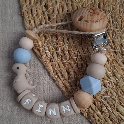 Speenkoord met naam Dino in beige, handgemaakt en gepersonaliseerd voor jongens.